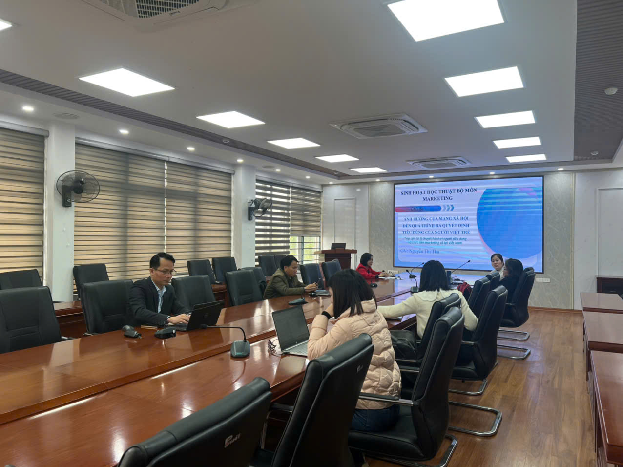 A group of people sitting at a table in a meeting room

Description automatically generated