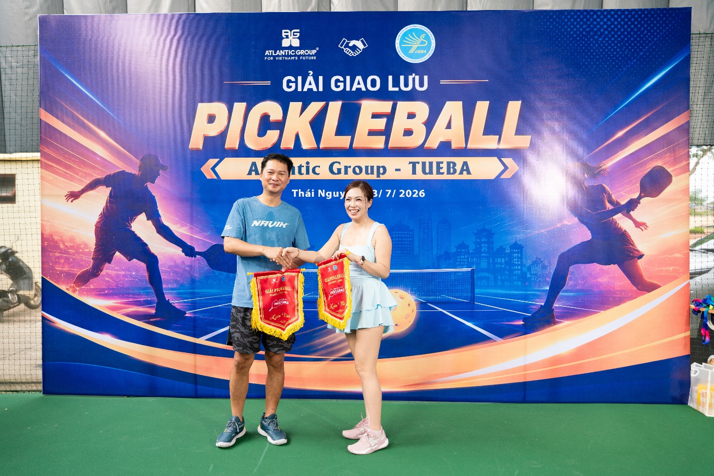 A person and person holding banners in front of a banner

Description automatically generated